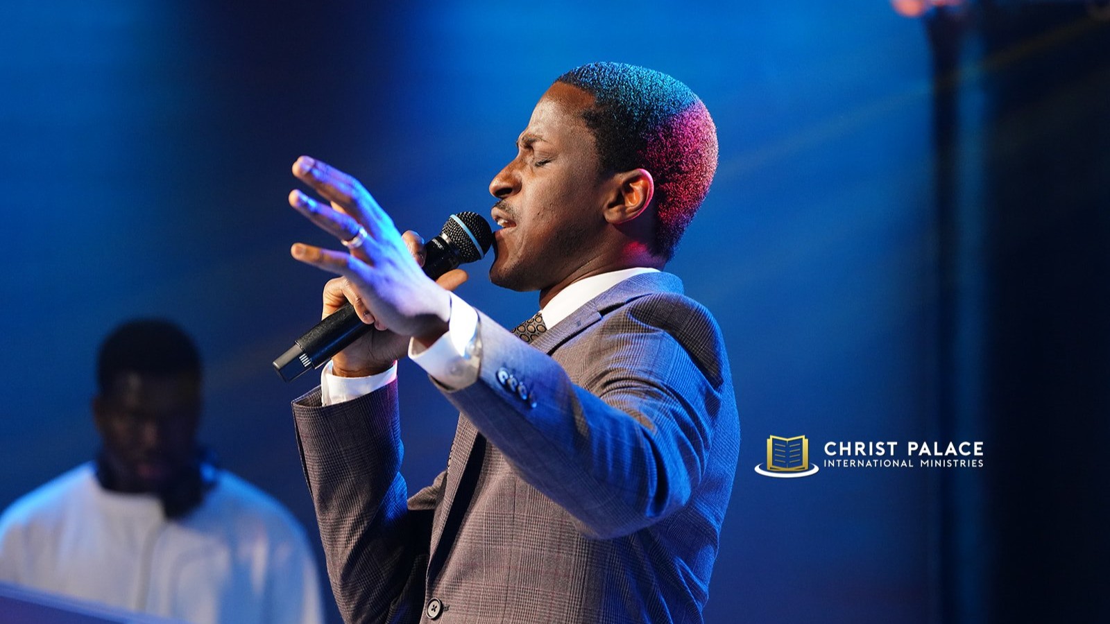 Worship leader singing at Christ Palace