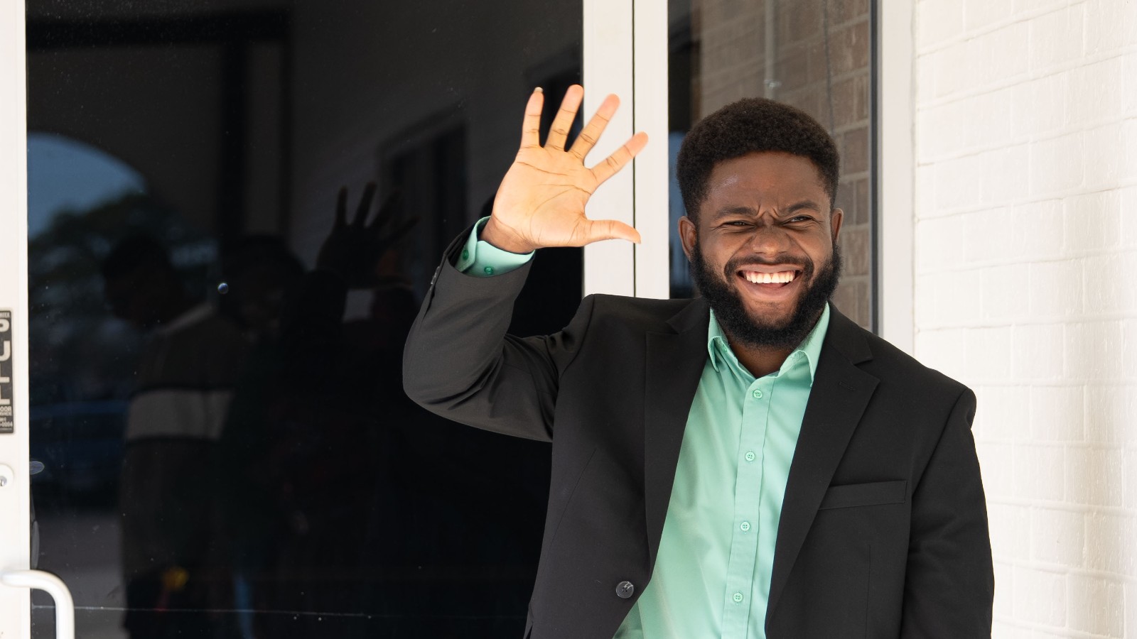 A greeter waving at the sanctuary door